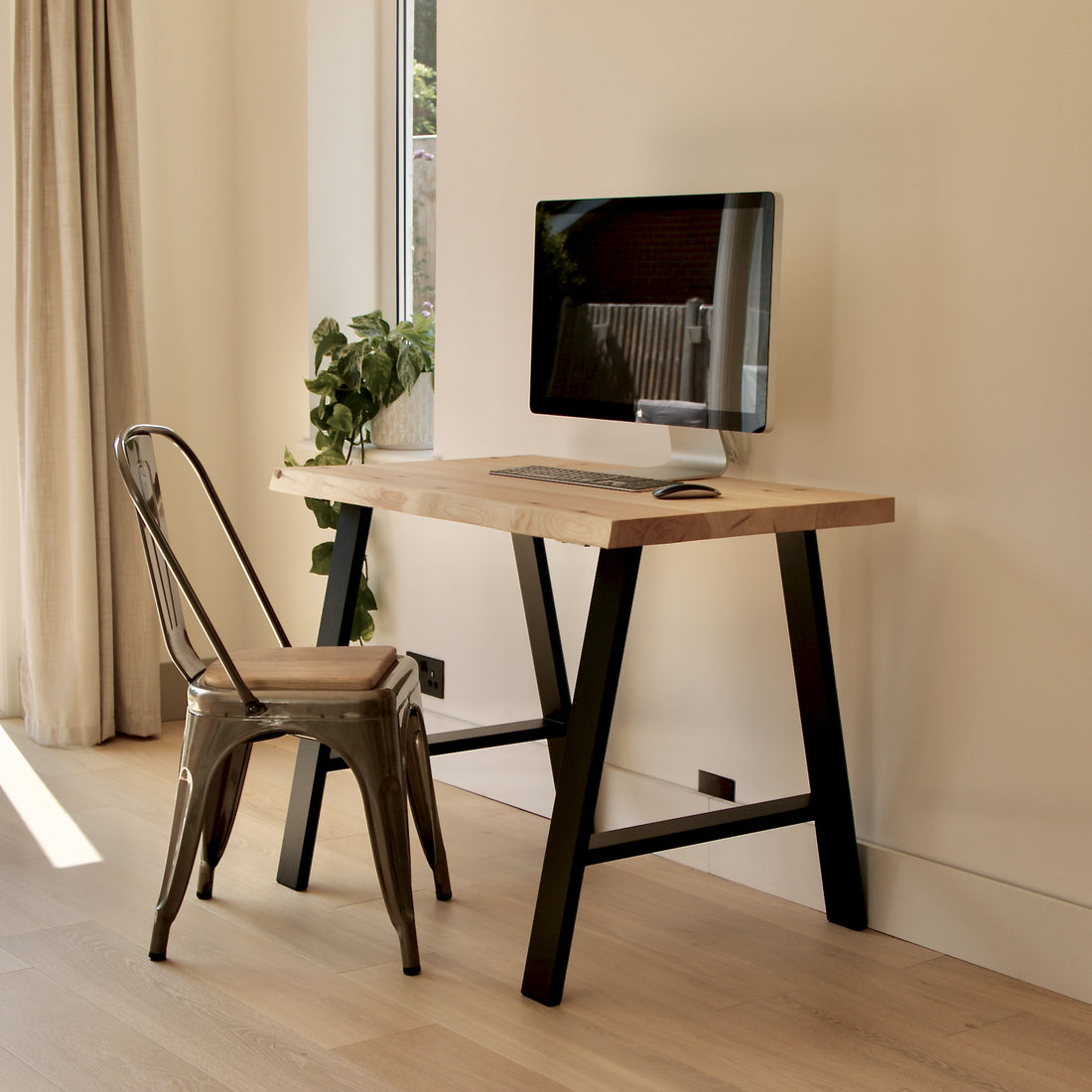 Modern home office with a wooden desk, chair, and computer monitor.