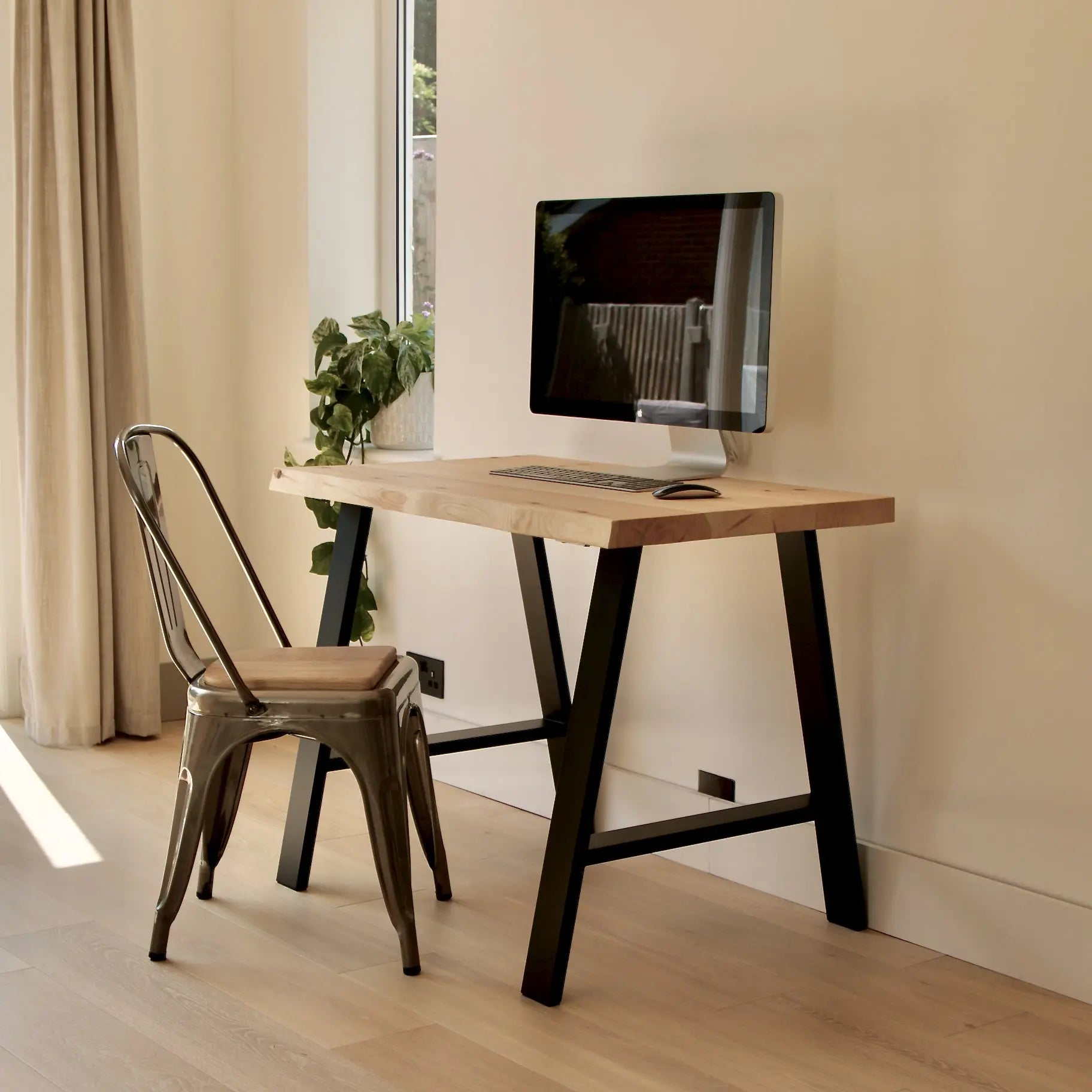 Modern home office with a wooden desk, chair, and computer monitor.