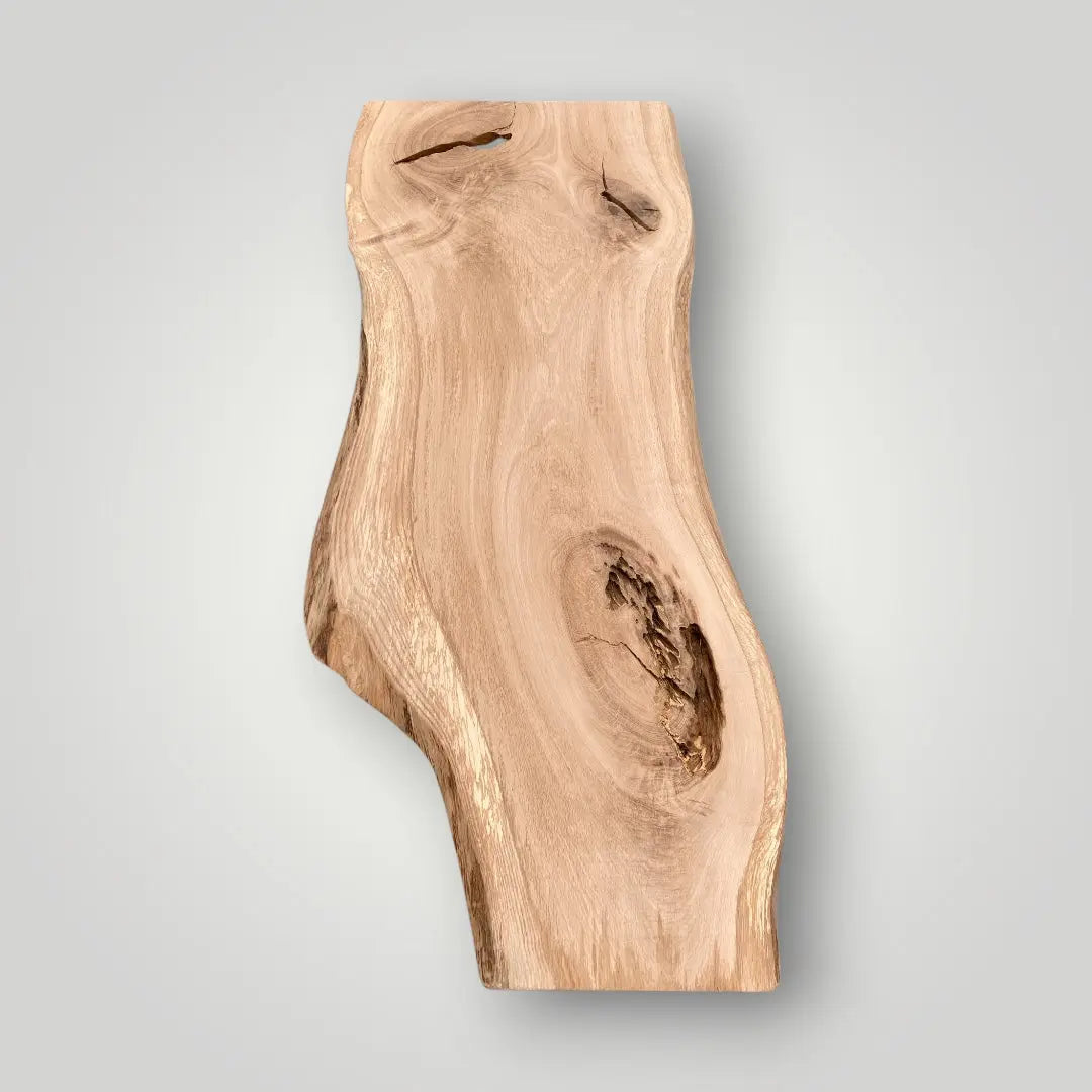 Wooden cutting board with natural edge on a gray background