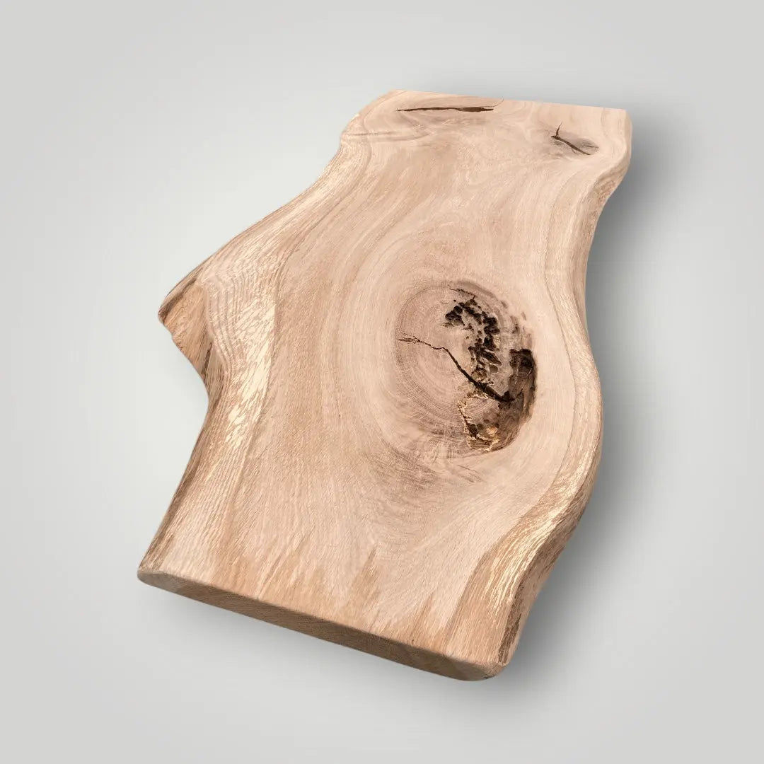 Wooden cutting board with natural edge on a light gray background