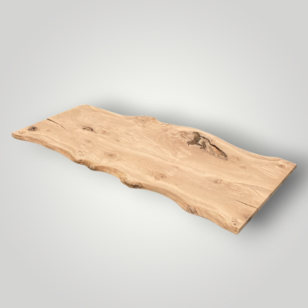 Wooden oak table top with natural edge on a gray background
