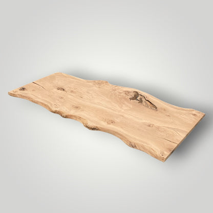 Wooden oak table top with natural edge on a gray background