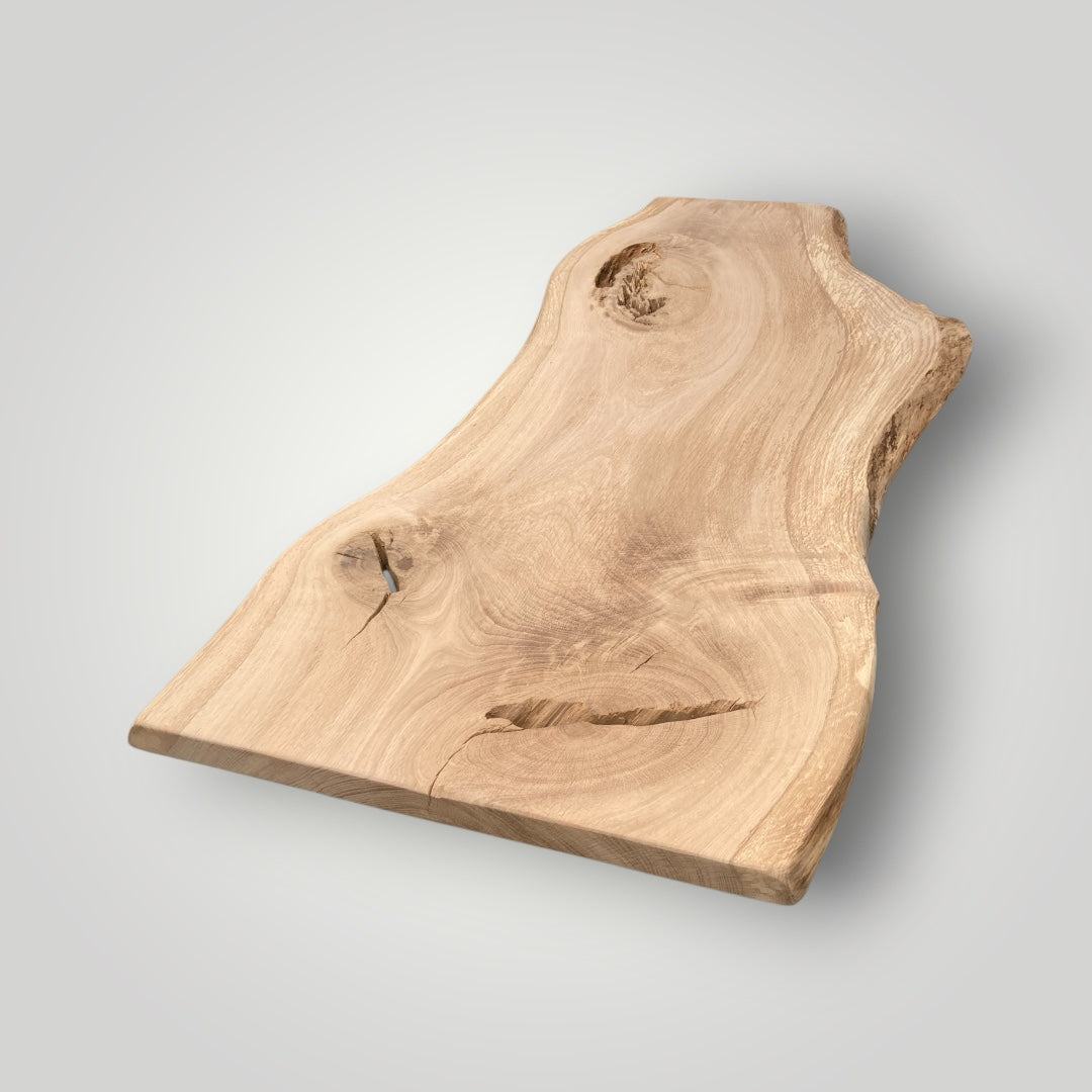 Wooden cutting board with natural edge on a light gray background