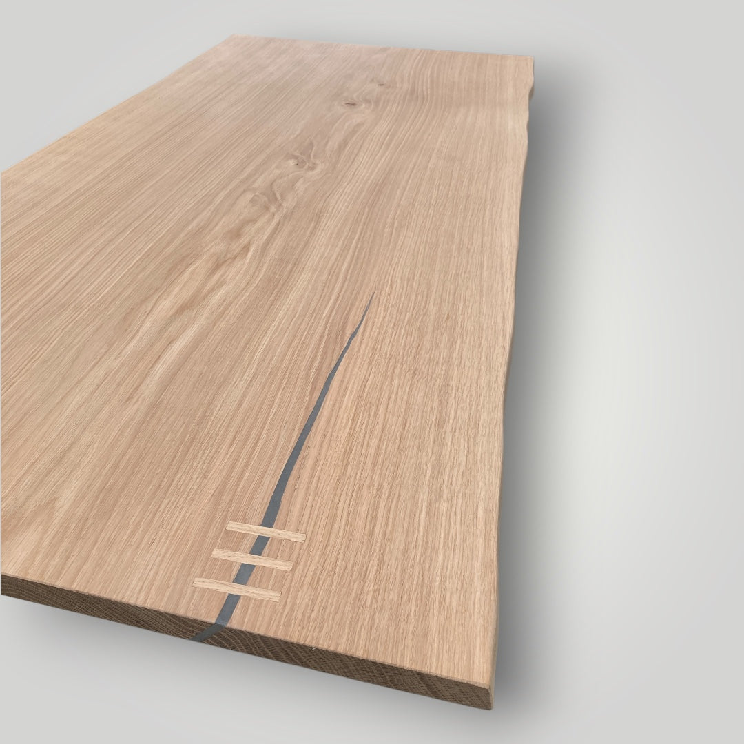 Wooden cutting board with a visible brand logo on a light gray background