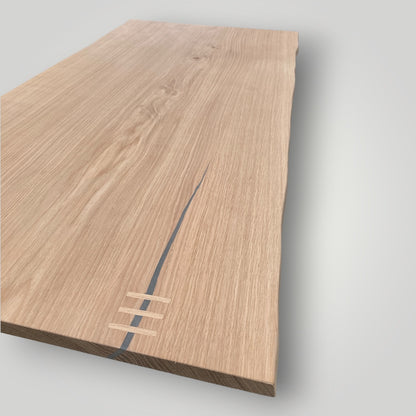 Wooden cutting board with a visible brand logo on a light gray background